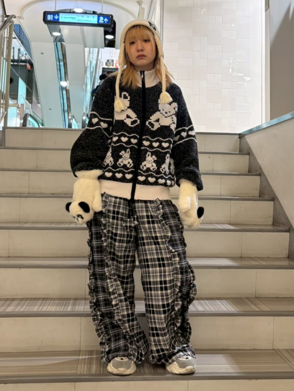 ブラック系のその他アウター、ブラック系のその他パンツ、ホワイト系のニットキャップ/ビーニーを着用したレディースの冬コーディネートの2枚目の写真