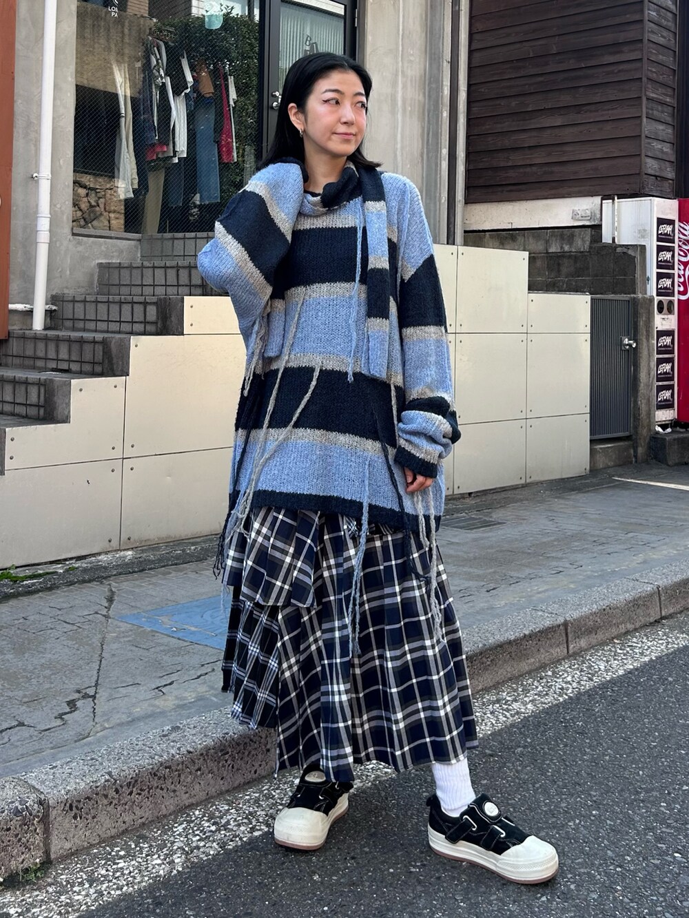 ブルー系のスカート、グレー系のニット/セーターを着用したレディースの秋コーディネートの3枚目の写真