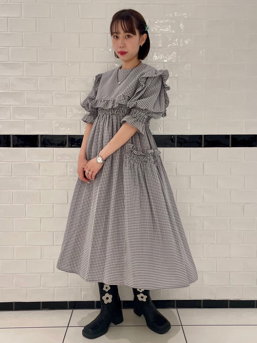 ホワイト系のワンピース、ブラック系のブーツを着用したレディースの春コーディネートの2枚目の写真