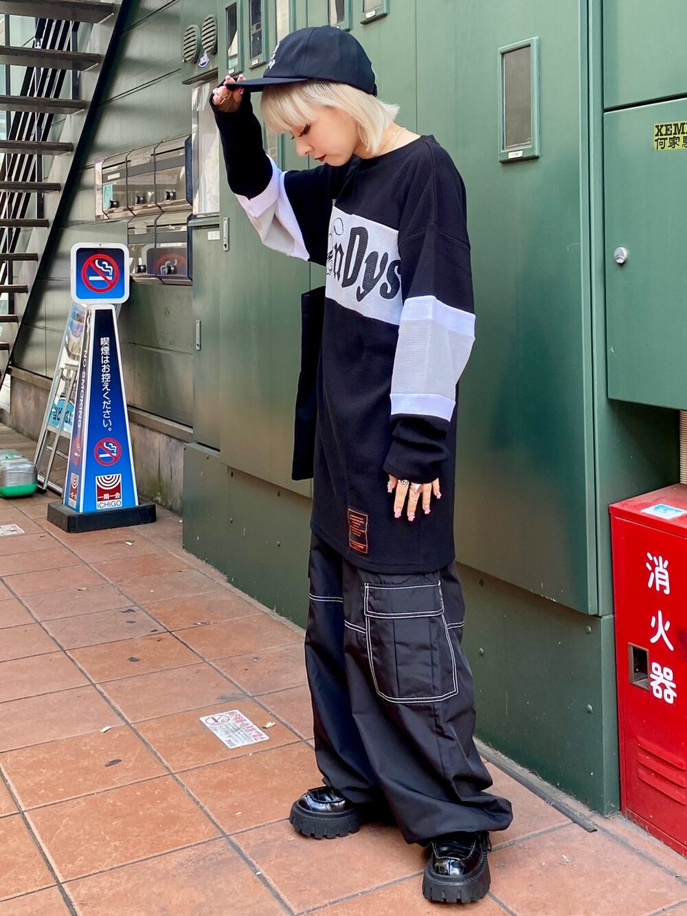 ブラック系のTシャツ/カットソー、ブラック系のカーゴパンツ、ブラック系のトートバッグを着用したレディースの夏コーディネートの3枚目の写真