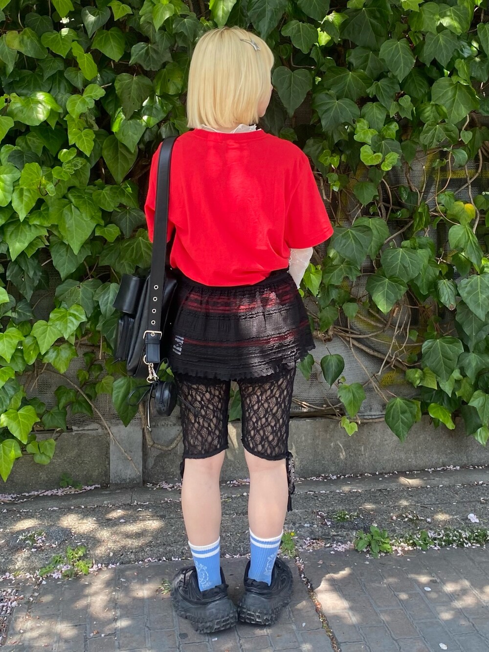 レッド系のTシャツ/カットソー、ホワイト系のその他トップス、ブラック系のスカートを着用したレディースの春コーディネートの3枚目の写真