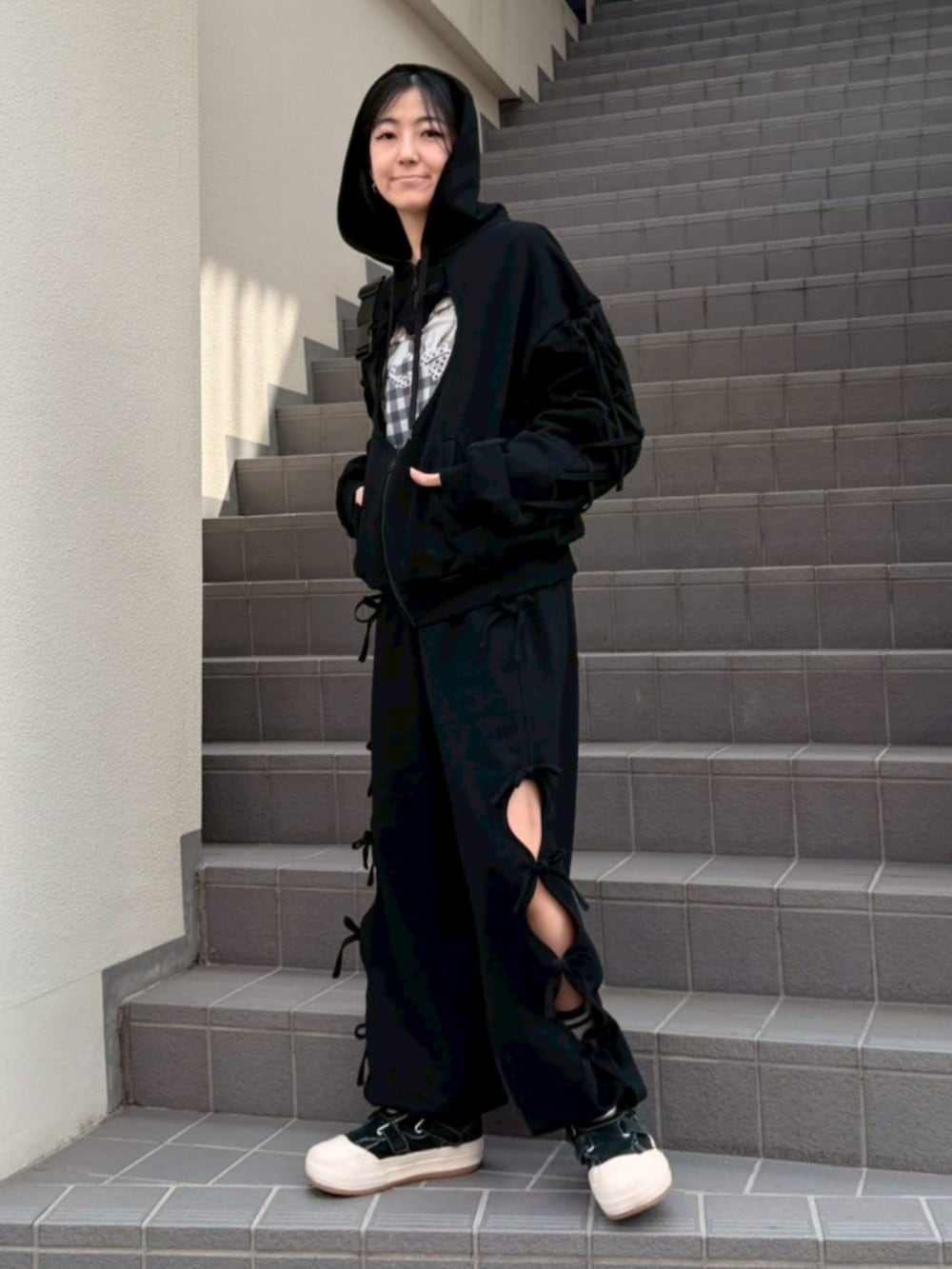 ブラック系のボディバッグ/ウエストポーチ、ブラック系のパーカー、ブラック系のTシャツ/カットソーを着用したレディースの春コーディネートの2枚目の写真