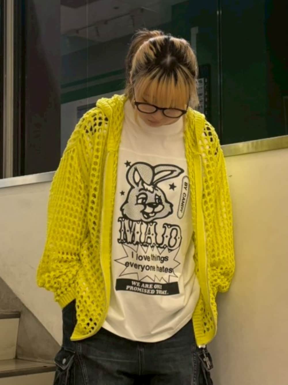 ブルー系のデニムパンツ、イエロー系のパーカー、ホワイト系のTシャツ/カットソーを着用したレディースの春コーディネートの3枚目の写真