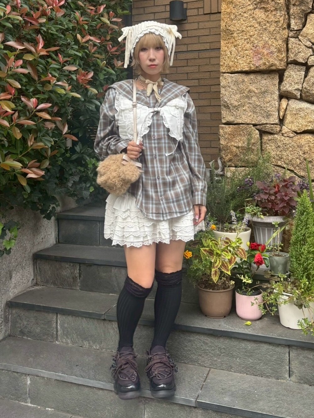 ブラウン系のシャツ/ブラウス、ホワイト系のベスト、ホワイト系のスカートを着用したレディースの秋コーディネートの3枚目の写真