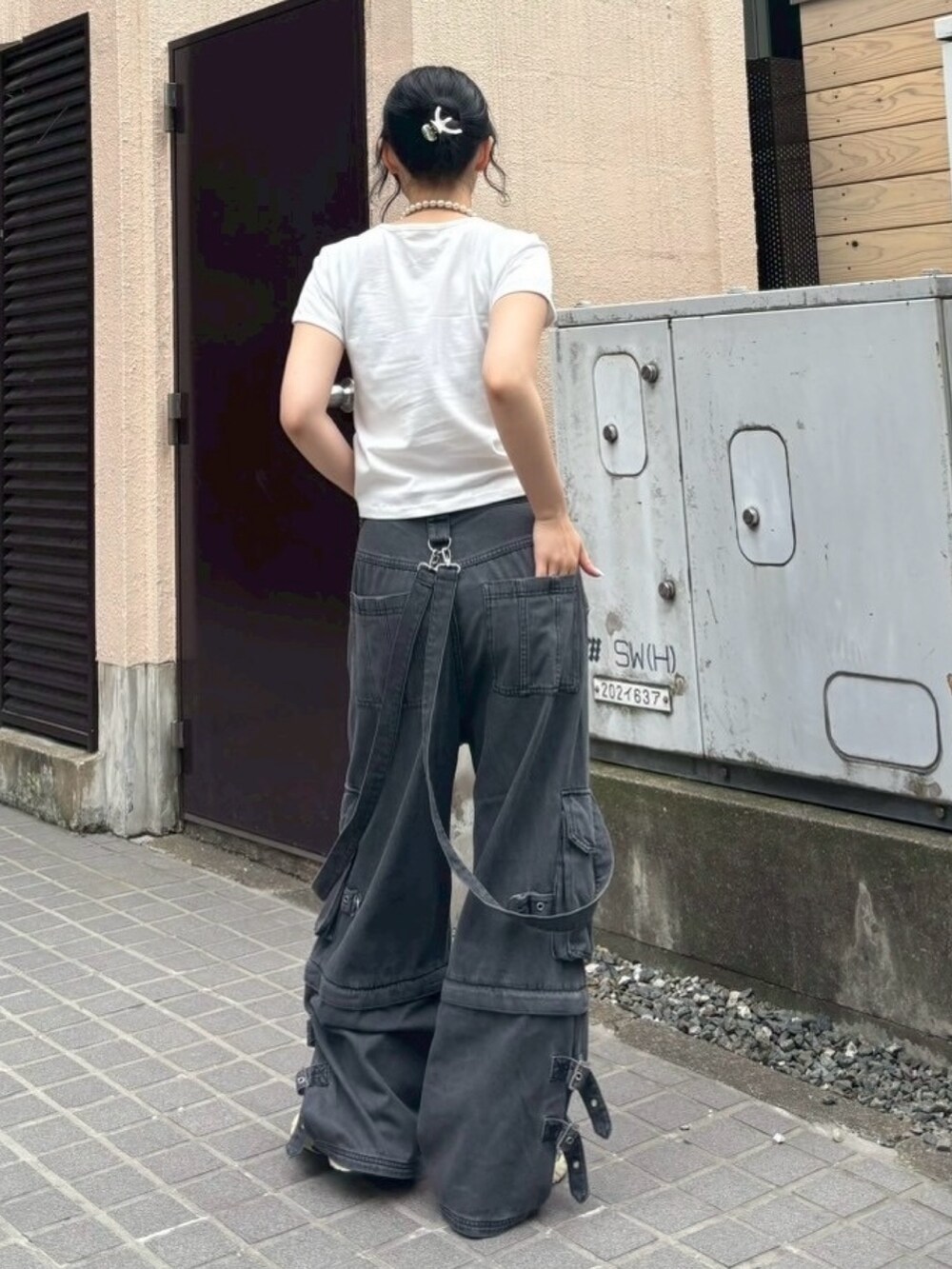 ブラック系のボディバッグ/ウエストポーチ、ブラック系のデニムパンツ、ホワイト系のTシャツ/カットソーを着用したレディースの夏コーディネートの5枚目の写真