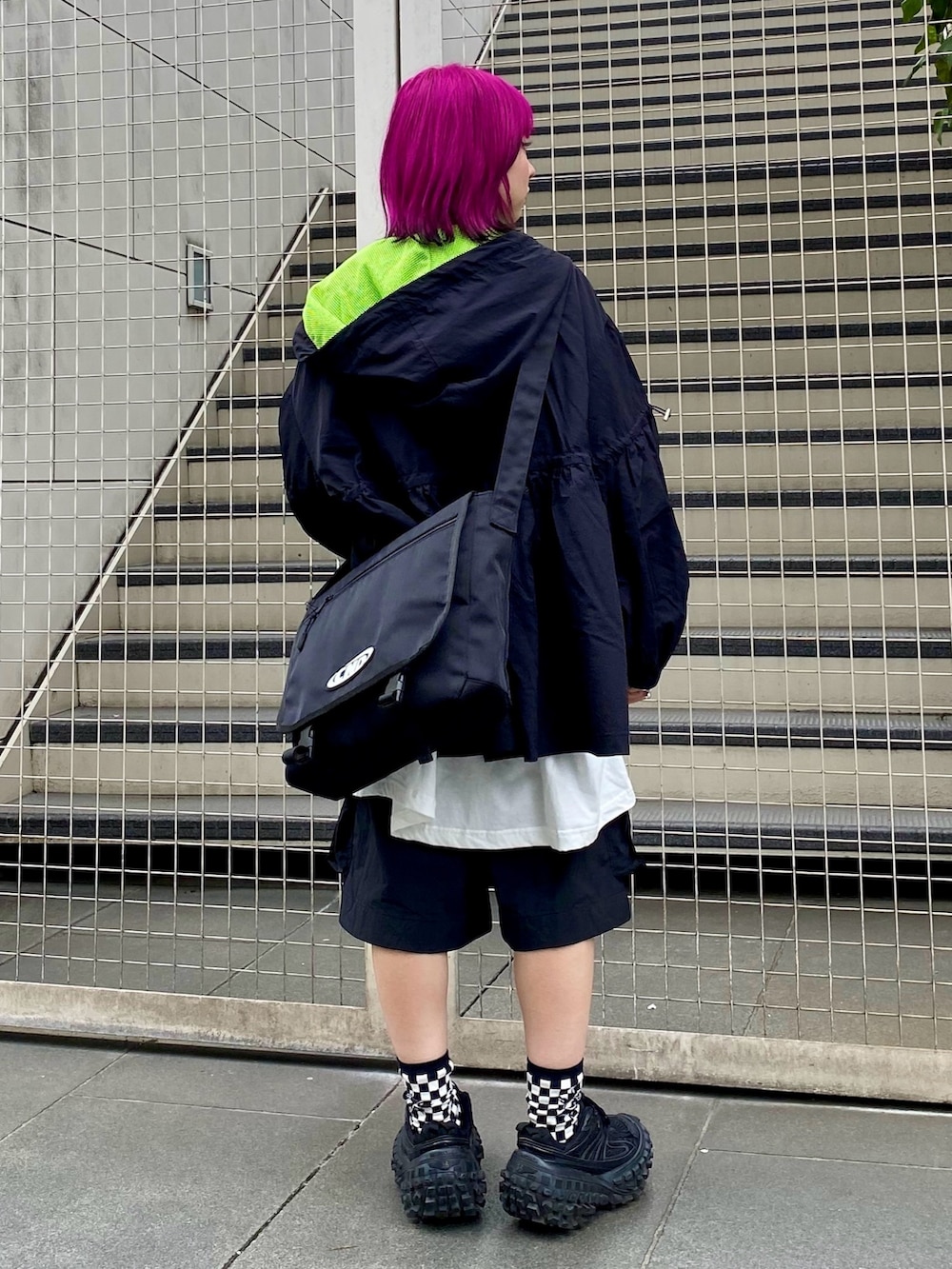 ブラック系のナイロンジャケット、ホワイト系のTシャツ/カットソー、ブラック系のショルダーバッグを着用したレディースの春コーディネートの5枚目の写真