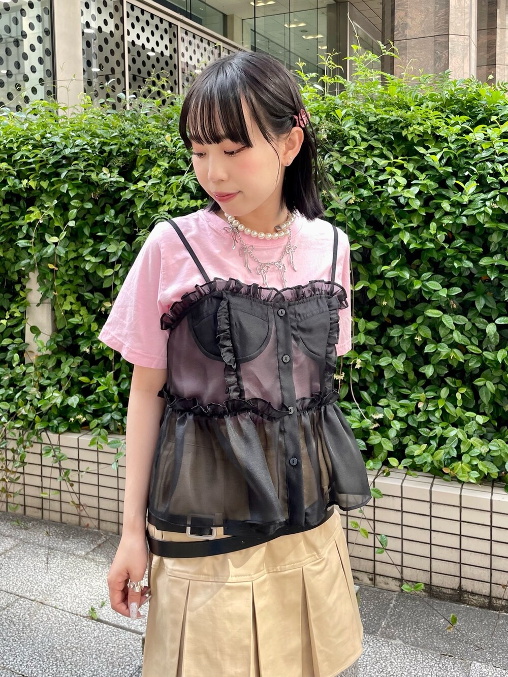 ピンク系のTシャツ/カットソー、ブラック系のキャミソール、ベージュ系のスカートを着用したレディースの春コーディネートの4枚目の写真