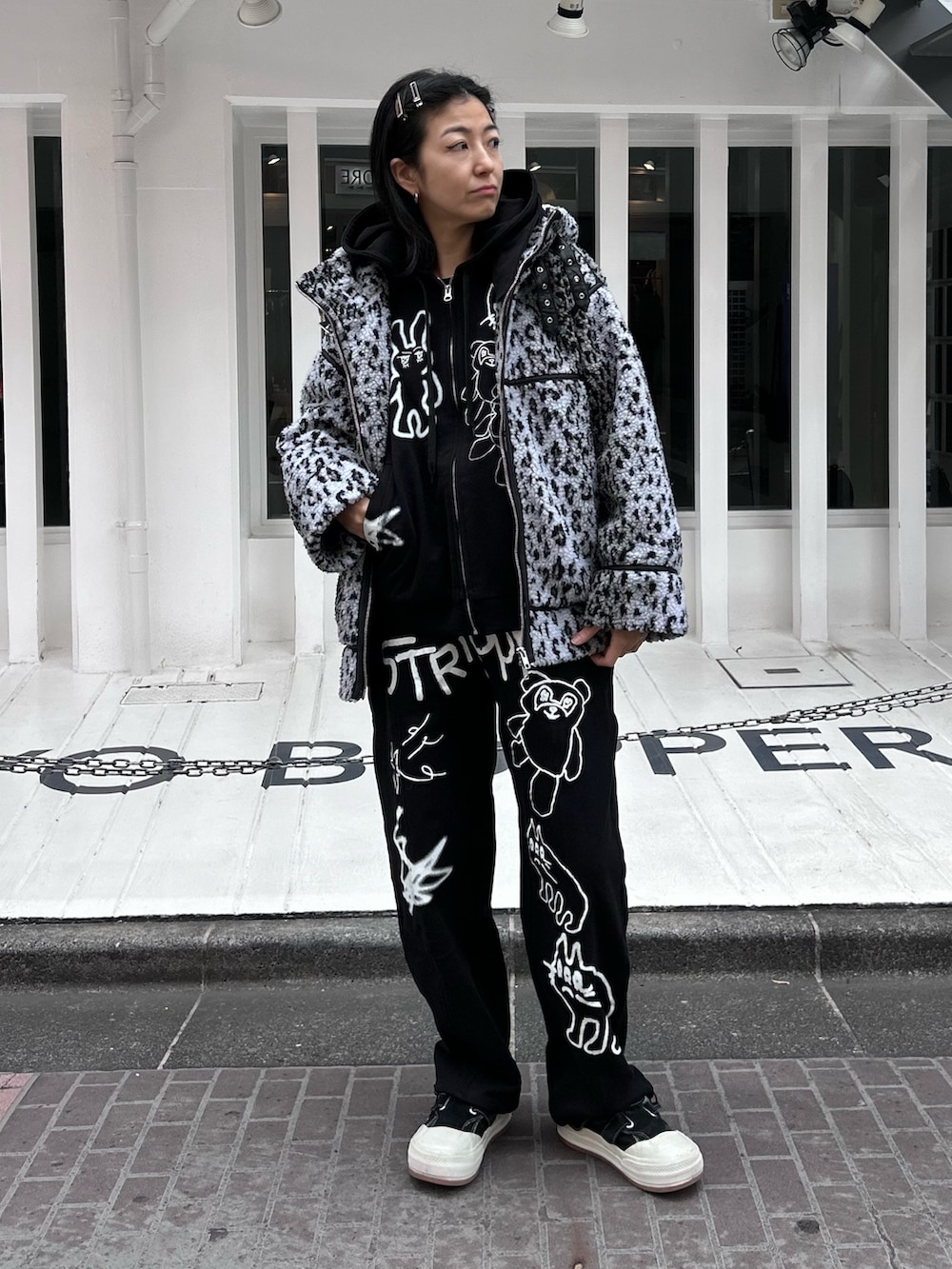 ブラック系のパーカー、グレー系のダウンジャケット/コート、ブラック系のスウェットパンツを着用したレディースの冬コーディネートの2枚目の写真