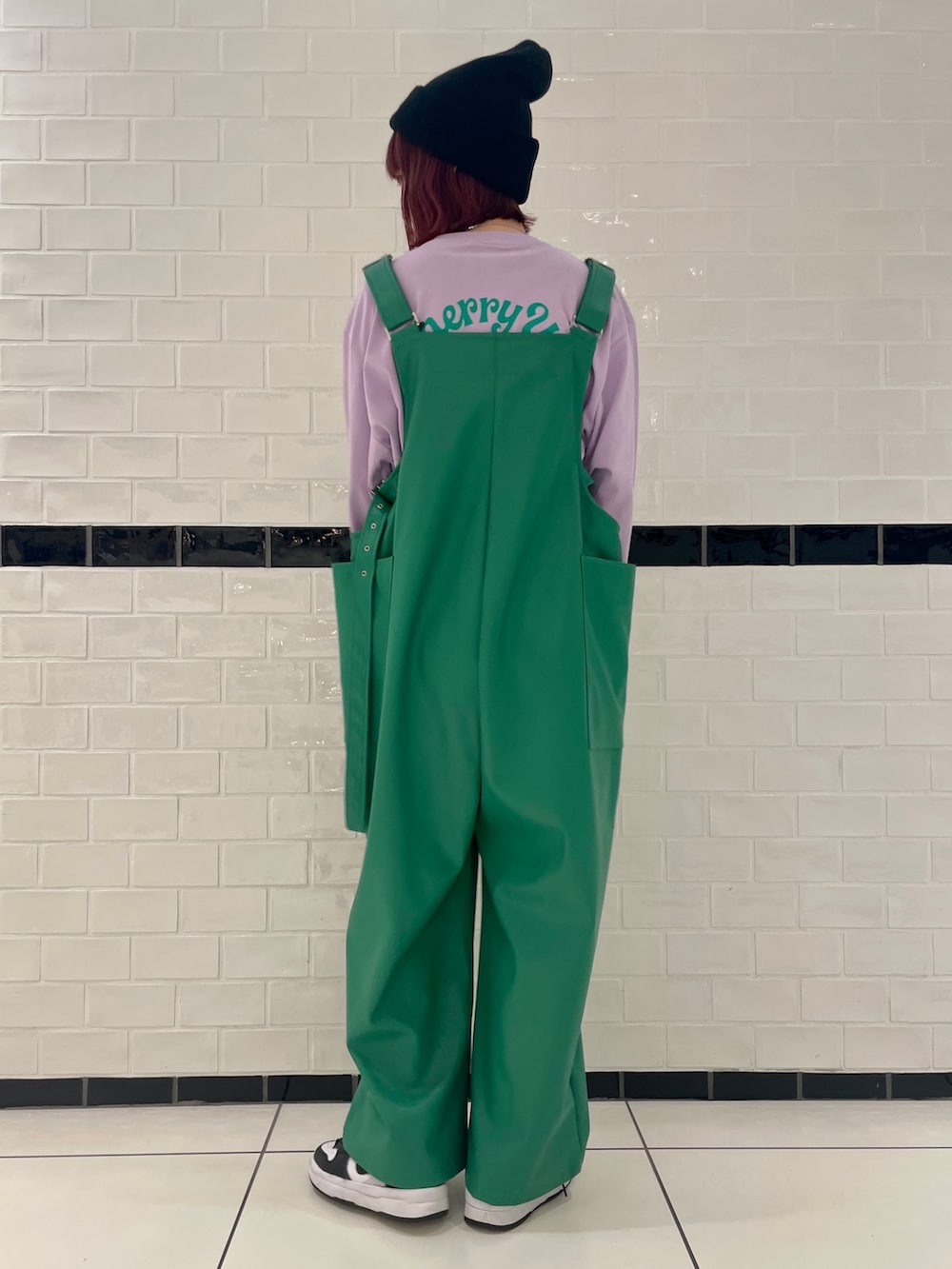 パープル系のTシャツ/カットソー、グリーン系のサロペット/オーバーオール、ブラック系のニットキャップ/ビーニーを着用したレディースの冬コーディネートの4枚目の写真