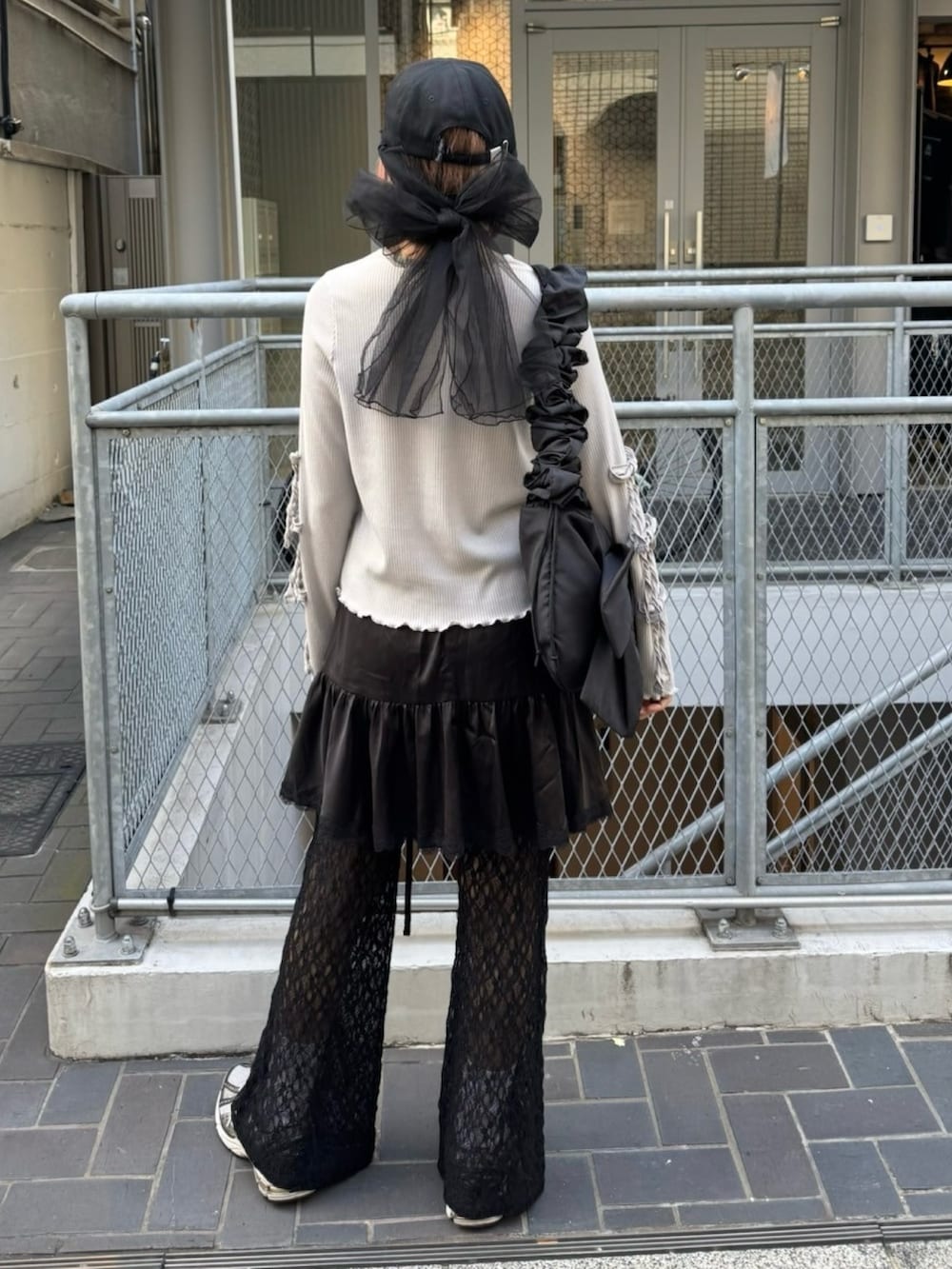 グレー系のTシャツ/カットソー、ブラック系のその他パンツ、ブラック系のショルダーバッグを着用したレディースの春コーディネートの5枚目の写真