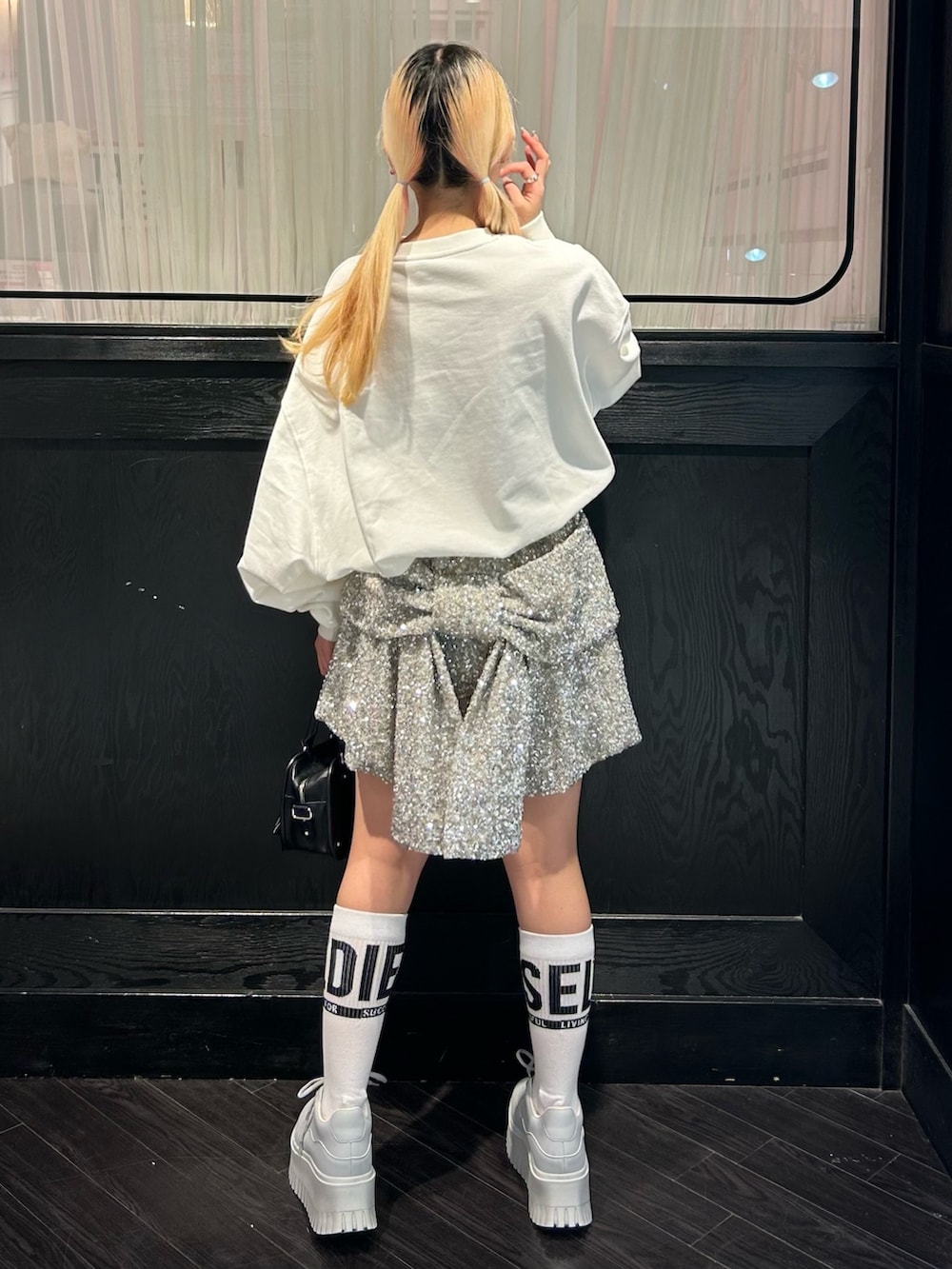 ホワイト系のスウェット、シルバー系のその他パンツ、ブラック系のショルダーバッグを着用したレディースの秋コーディネートの5枚目の写真