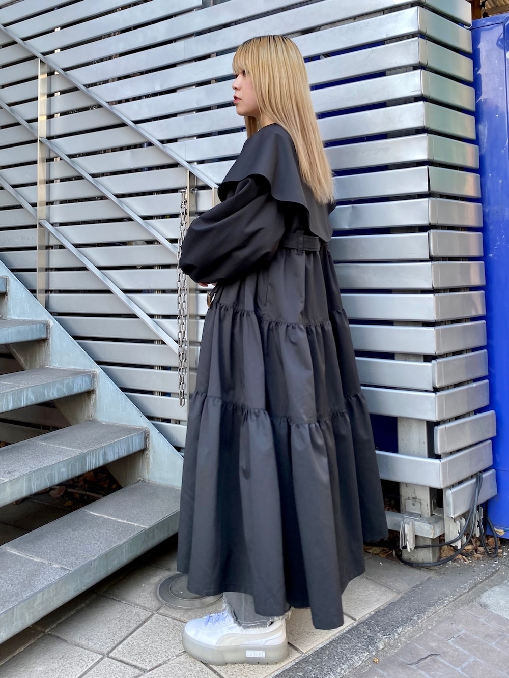 ブルー系のデニムパンツ、ブラック系のトレンチコート、グレー系のTシャツ/カットソーを着用したレディースの冬コーディネートの3枚目の写真