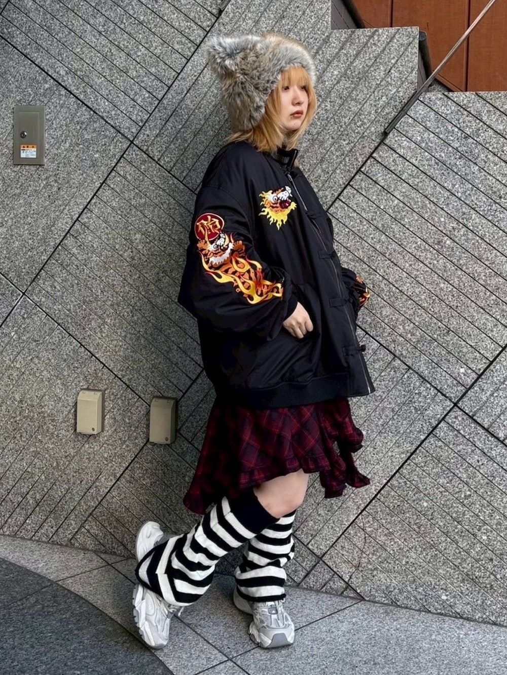 レッド系のワンピース、ブラック系のニット/セーター、ブラック系のMA-1を着用したレディースの秋コーディネートの5枚目の写真