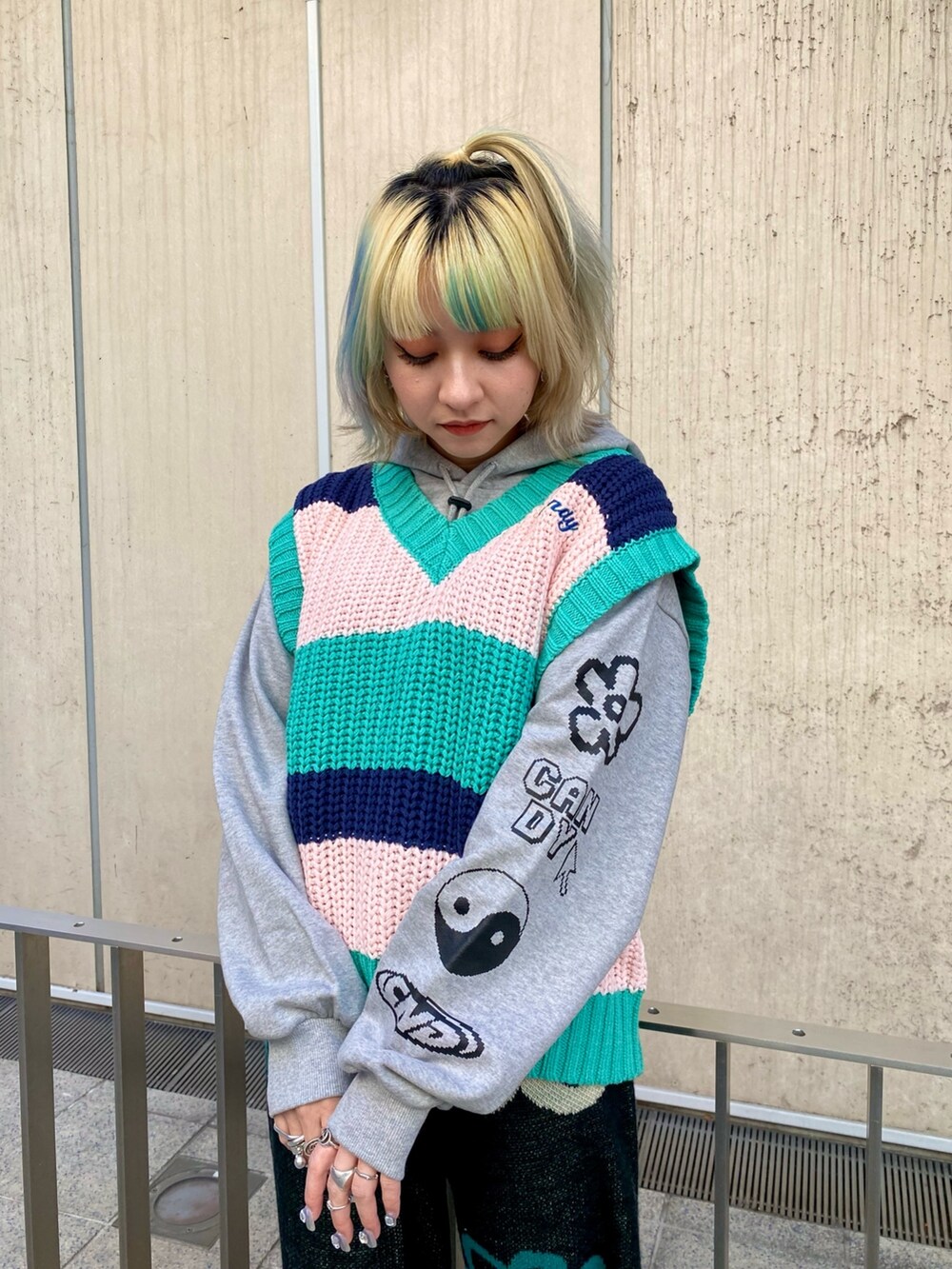 グレー系のパーカー、グリーン系のベスト、ブラック系のその他パンツを着用したレディースの冬コーディネートの4枚目の写真