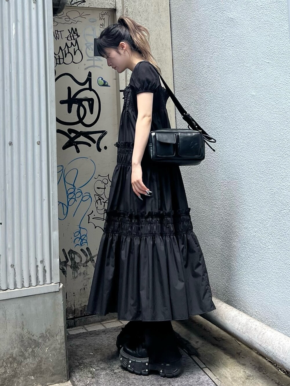 ブラック系のショルダーバッグ、ブラック系のワンピース、ブラック系のTシャツ/カットソーを着用したレディースの夏コーディネートの3枚目の写真