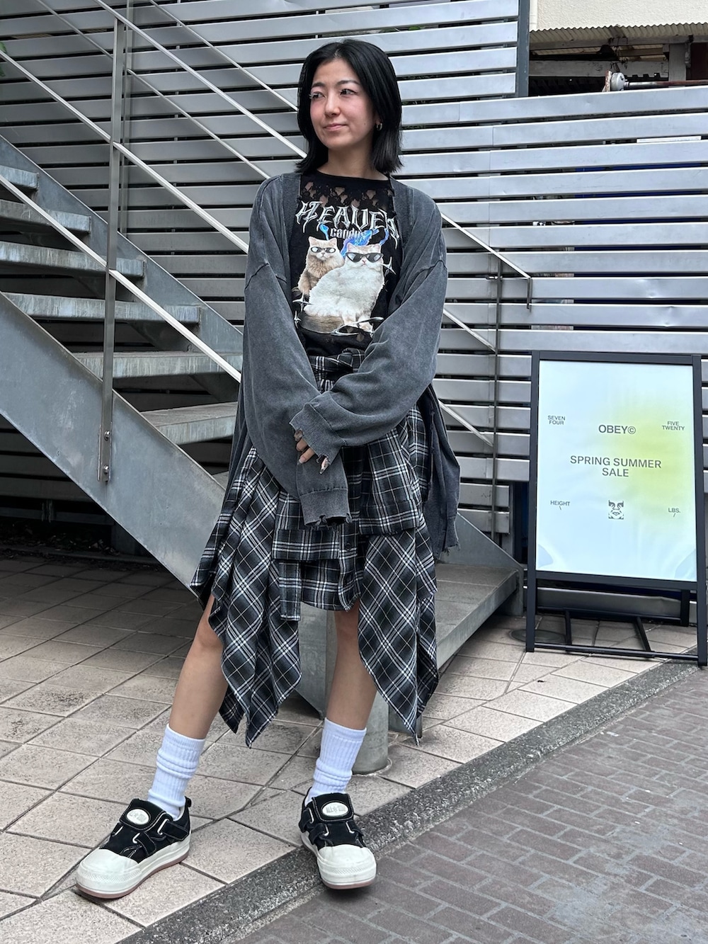 ブラック系のスカート、ブラック系のTシャツ/カットソー、グレー系のカーディガン/ボレロを着用したレディースの秋コーディネートの2枚目の写真