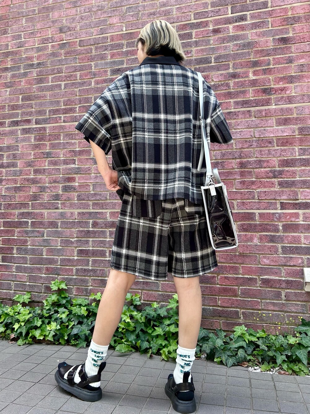 ブラック系のその他パンツ、ブラック系のポロシャツ、ブラック系のショルダーバッグを着用したレディースの春コーディネートの3枚目の写真