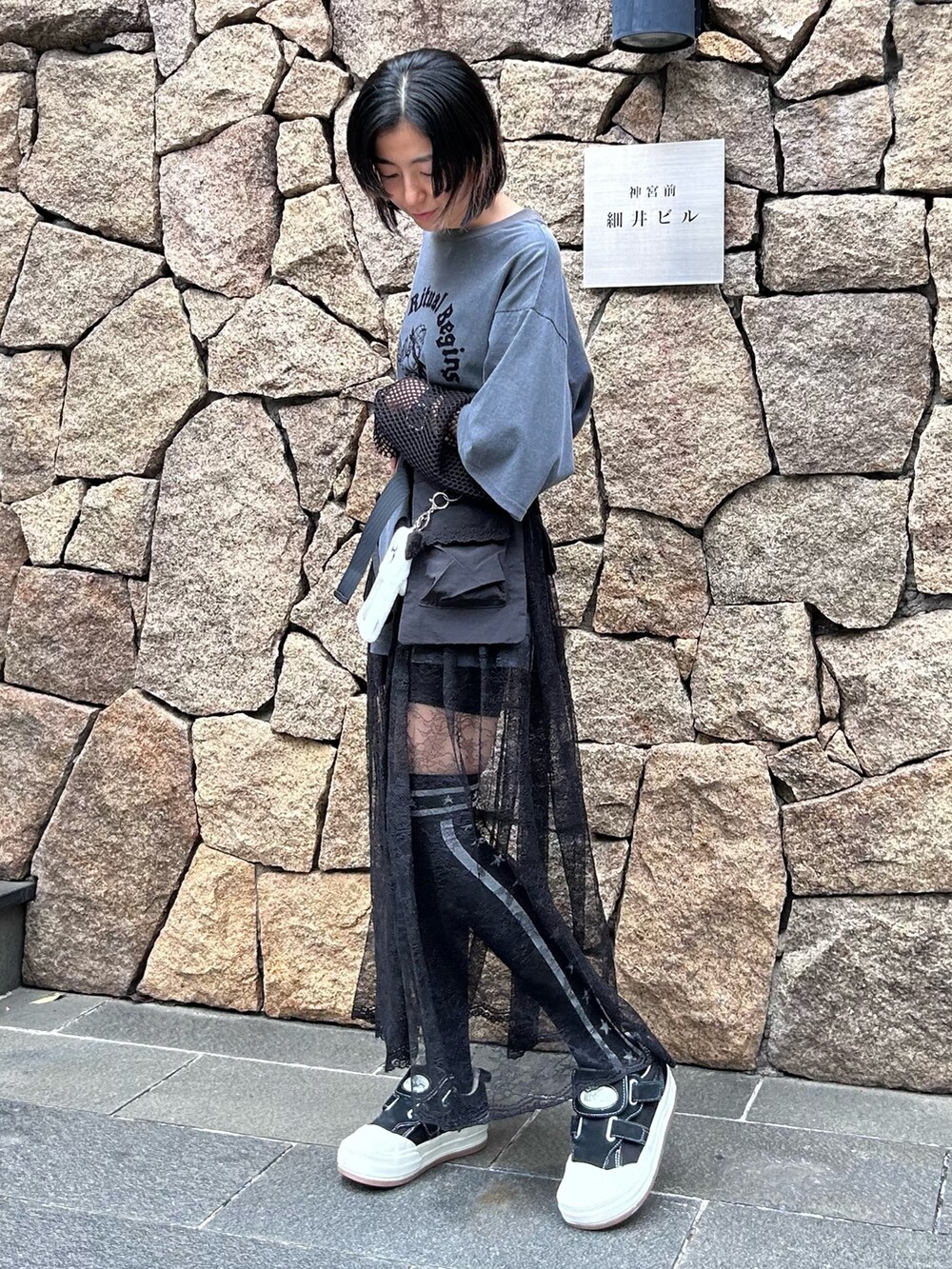 グレー系のTシャツ/カットソー、ブラック系のスカート、ブラック系のソックス/靴下を着用したレディースの春コーディネートの5枚目の写真