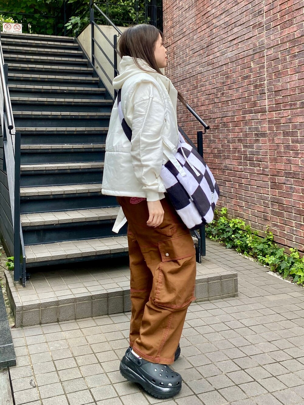 ホワイト系のショルダーバッグ、ブラウン系のカーゴパンツ、ホワイト系のパーカーを着用したレディースの秋コーディネートの2枚目の写真