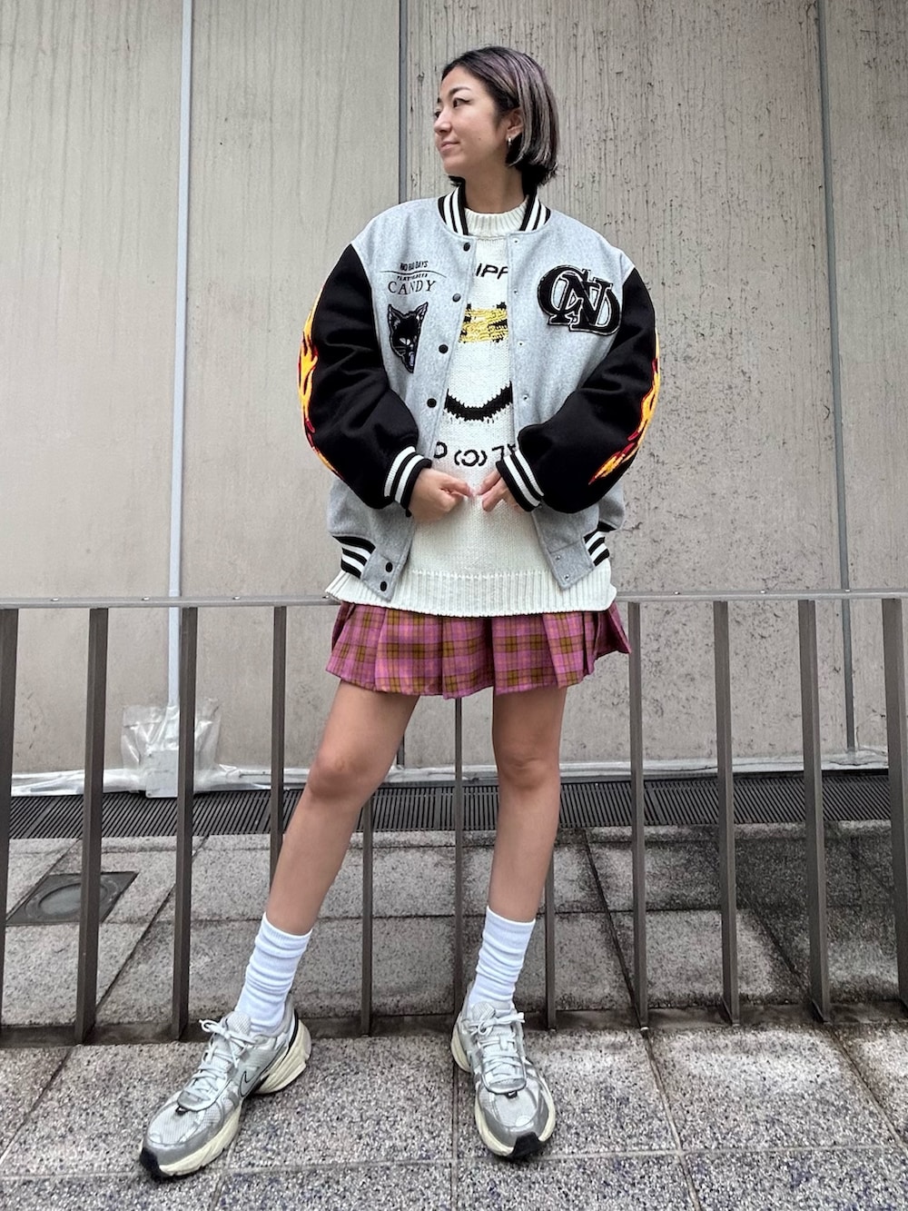 シルバー系のシューズ、ピンク系のスカート、ホワイト系のニット/セーターを着用したレディースの秋コーディネートの2枚目の写真