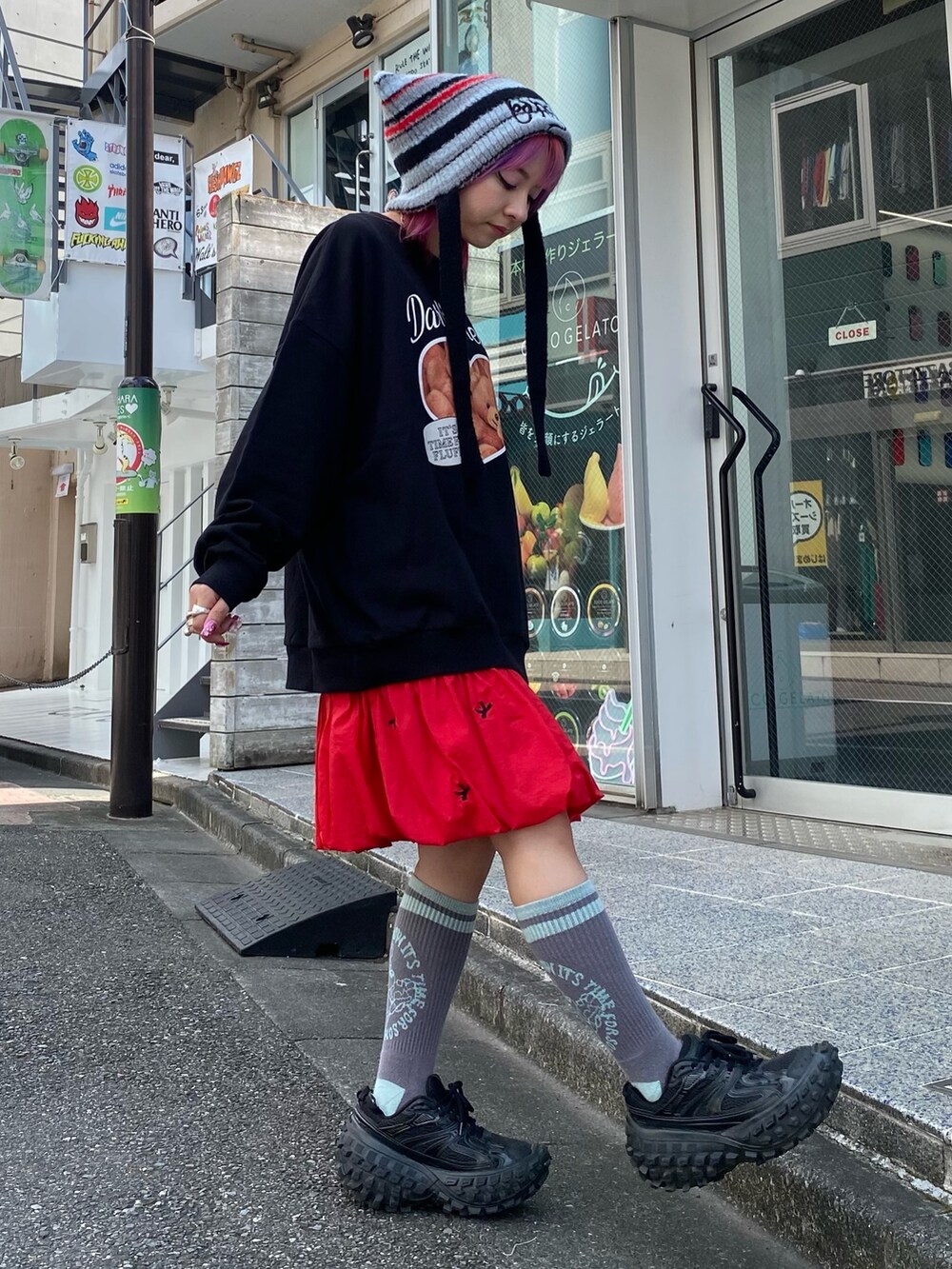 ブラック系のスウェット、レッド系のスカート、ブラック系のニットキャップ/ビーニーを着用したレディースの秋コーディネートの3枚目の写真