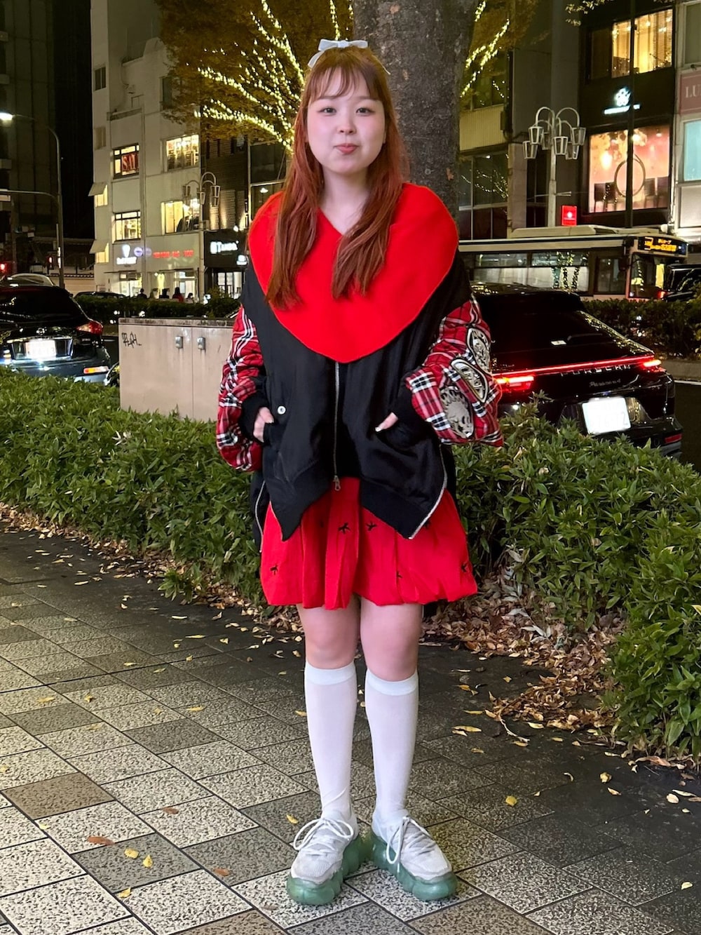 レッド系のスカート、ブラック系のMA-1、レッド系のニット/セーターを着用したレディースの冬コーディネートの3枚目の写真