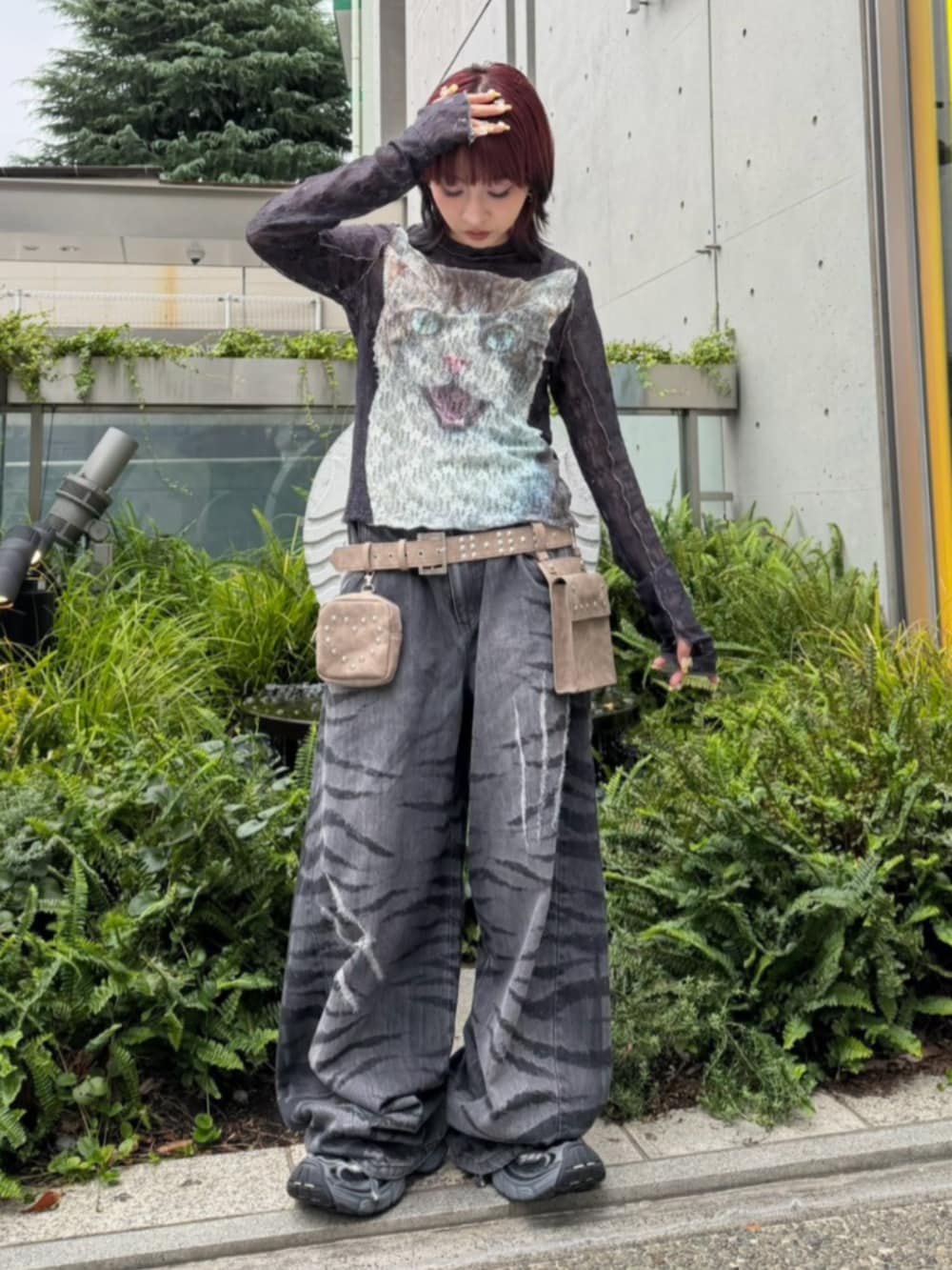 ブラック系のデニムパンツ、ホワイト系のTシャツ/カットソー、ブラウン系のボディバッグ/ウエストポーチを着用したレディースの秋コーディネートの2枚目の写真