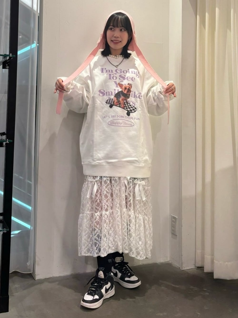 ホワイト系のシューズ、ホワイト系のスウェット、ピンク系のワンピースを着用したレディースの秋コーディネートの2枚目の写真