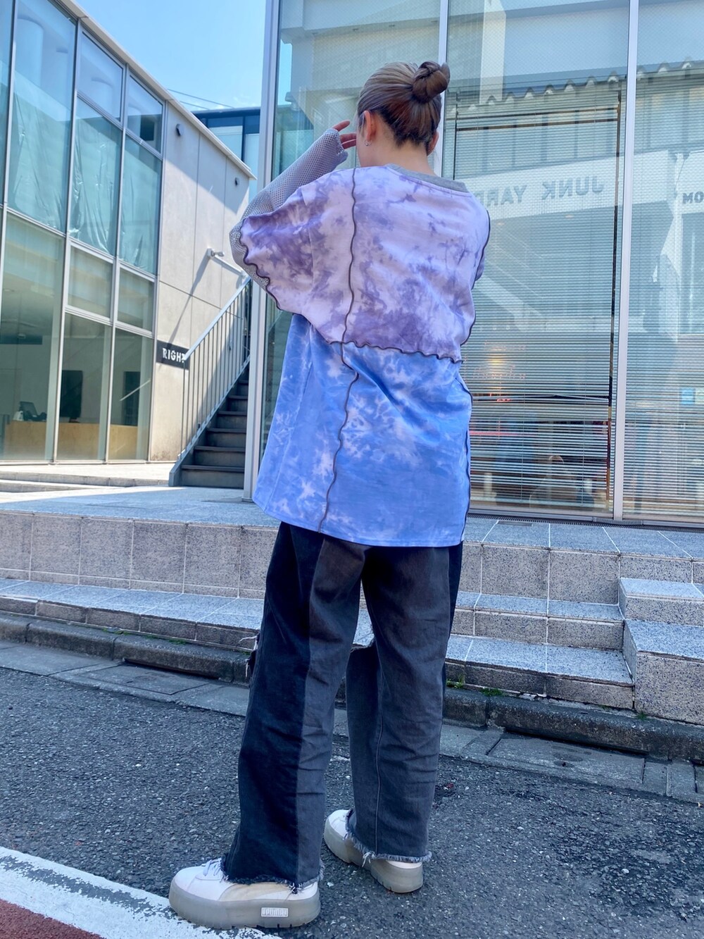 ブラック系のデニムパンツ、パープル系のTシャツ/カットソーを着用したレディースの春コーディネートの3枚目の写真