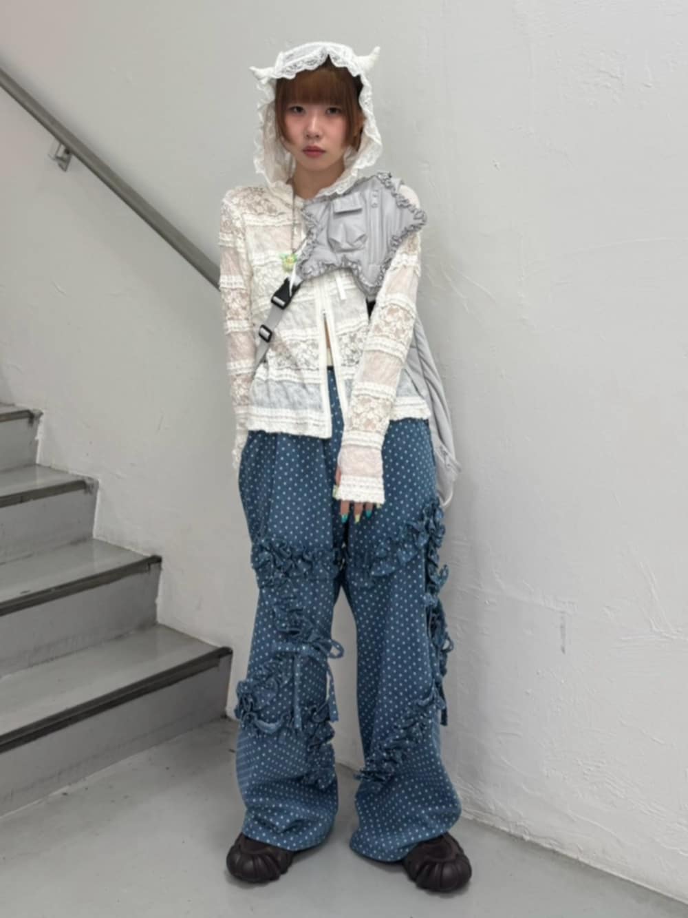 ブルー系のデニムパンツ、ホワイト系のパーカー、グレー系のショルダーバッグを着用したレディースの秋コーディネートの2枚目の写真