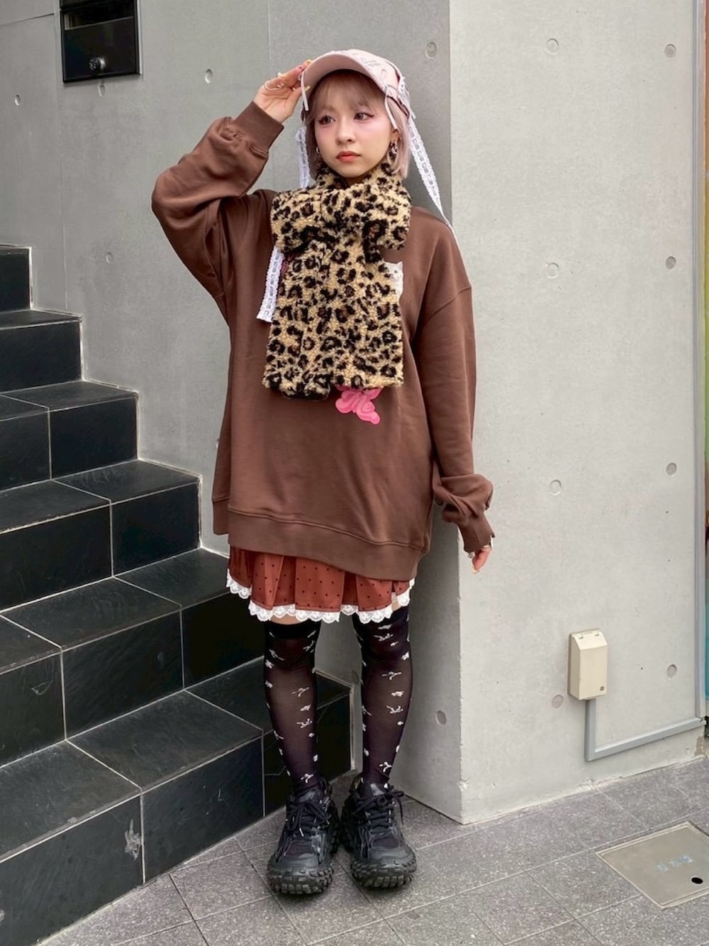 ブラウン系のスウェット、ブラウン系のスカート、ピンク系のキャップを着用したレディースの秋コーディネートの3枚目の写真