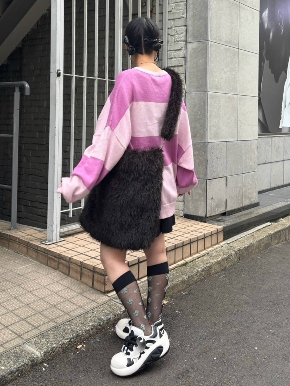 ブラック系のショルダーバッグ、ブラック系のスカート、ピンク系のニット/セーターを着用したレディースの秋コーディネートの4枚目の写真