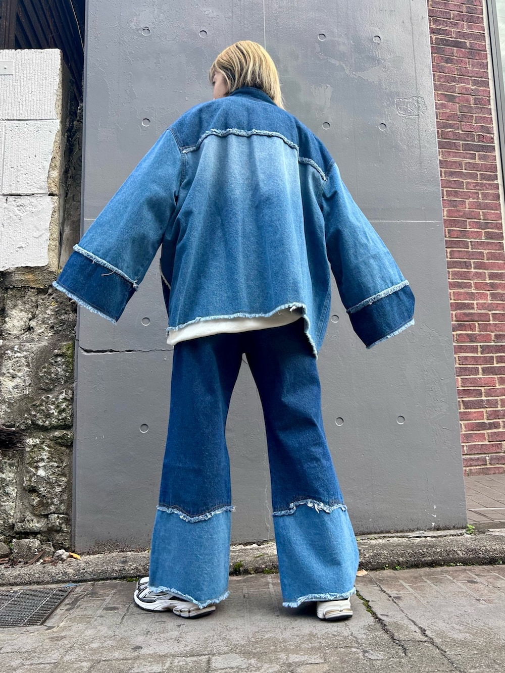 ブルー系のデニムジャケット、ブルー系のデニムパンツ、ホワイト系のスウェットを着用したレディースの冬コーディネートの3枚目の写真