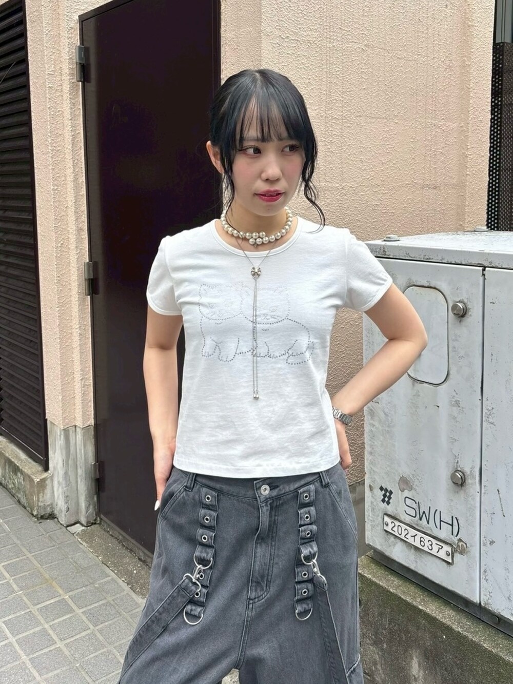 ブラック系のボディバッグ/ウエストポーチ、ブラック系のデニムパンツ、ホワイト系のTシャツ/カットソーを着用したレディースの夏コーディネートの6枚目の写真