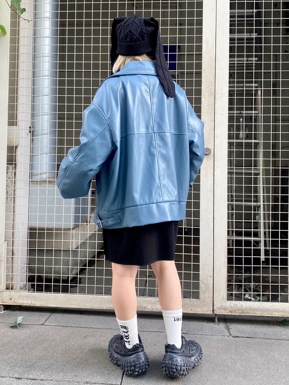 ブラック系のTシャツ/カットソー、ブルー系のライダースジャケット、ブラック系のニットキャップ/ビーニーを着用したレディースの秋コーディネートの3枚目の写真