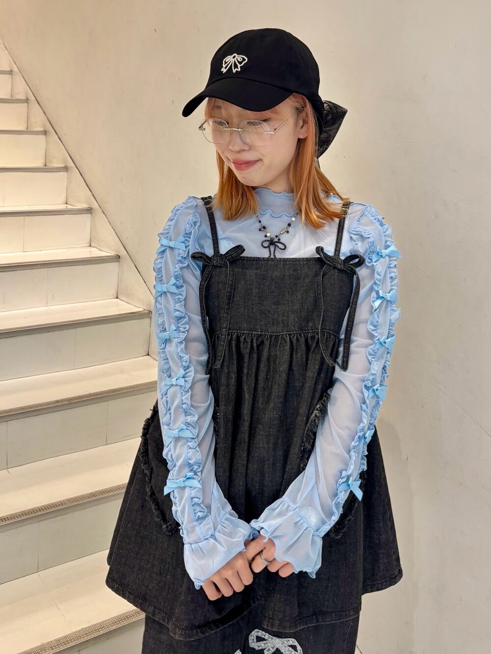 ブラック系のワンピース、ブラック系のデニムパンツ、ブルー系のその他トップスを着用したレディースの春コーディネートの5枚目の写真