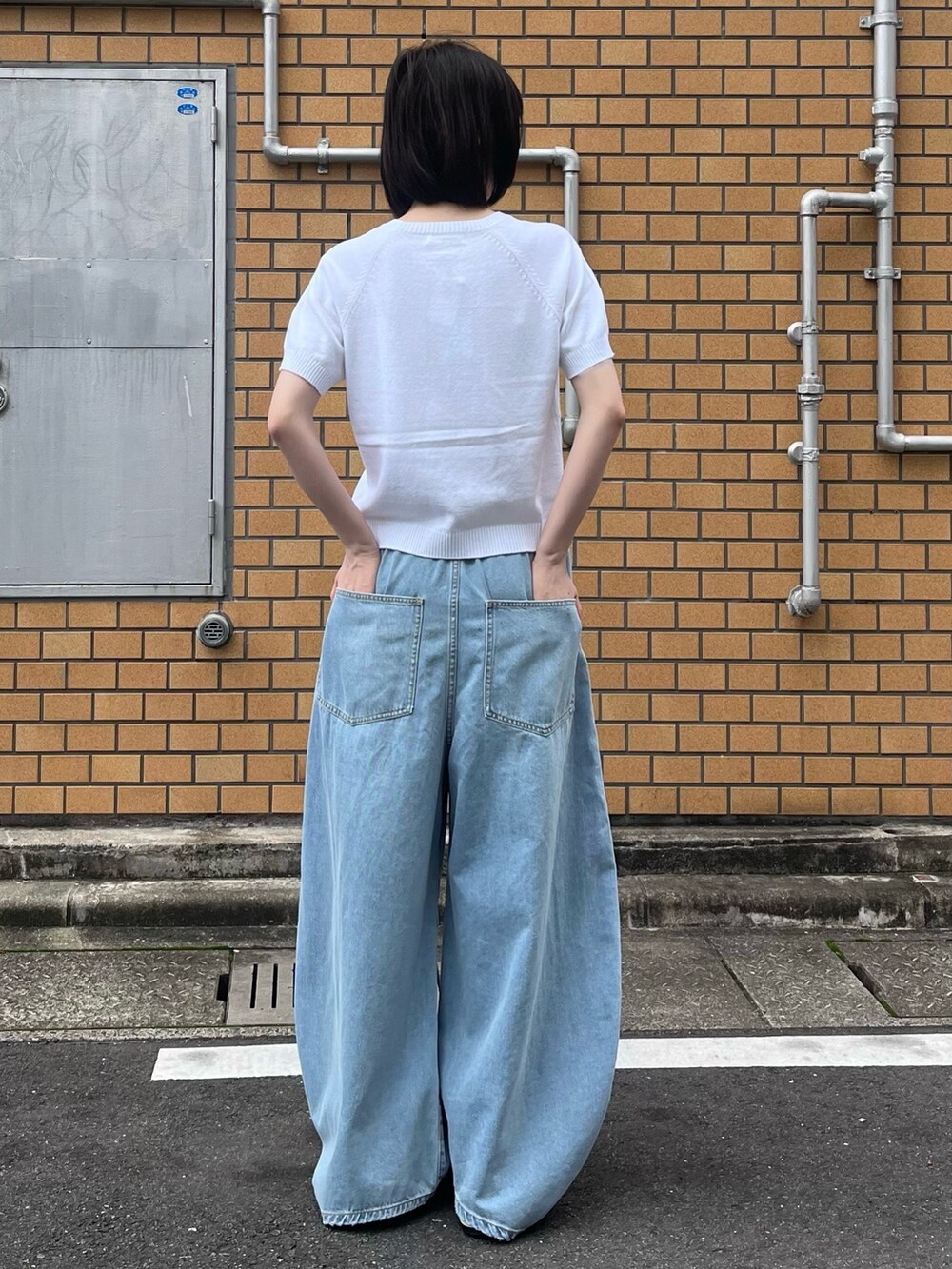 ブルー系のデニムパンツ、ホワイト系のニット/セーターを着用したレディースの夏コーディネートの3枚目の写真