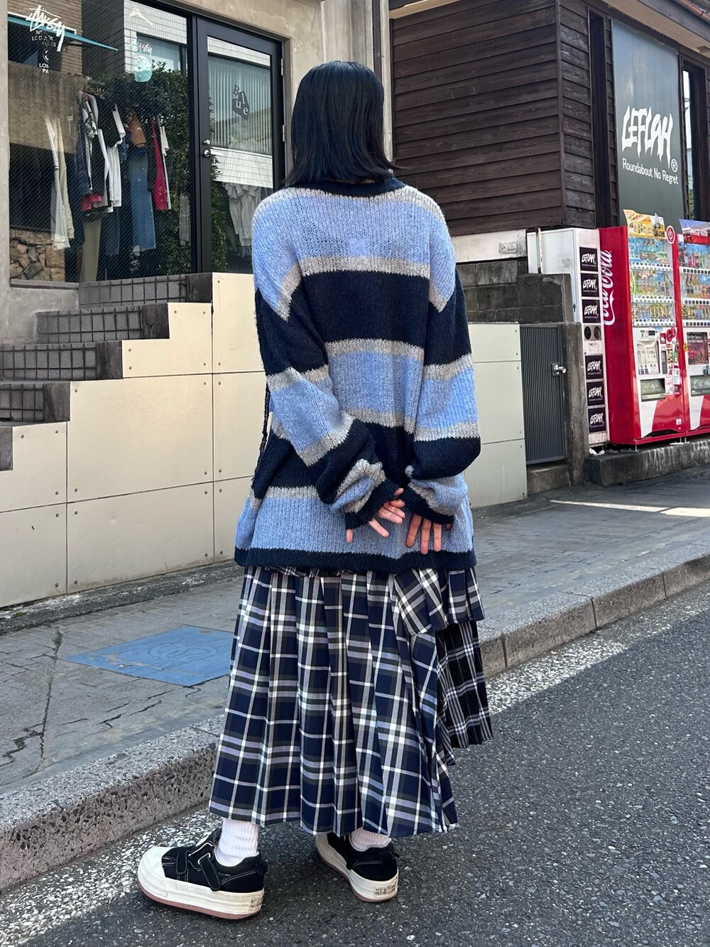 ブルー系のスカート、グレー系のニット/セーターを着用したレディースの秋コーディネートの5枚目の写真