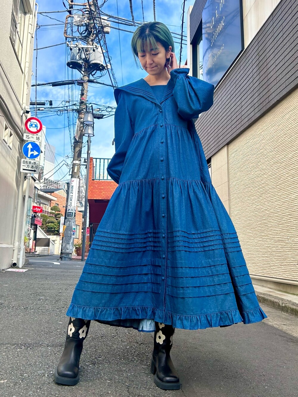 ブルー系のワンピース、ブラック系のブーツを着用したレディースの冬コーディネートの2枚目の写真