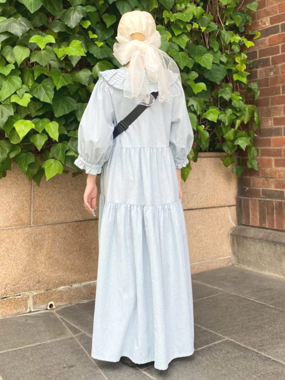 ブラック系のボディバッグ/ウエストポーチ、グリーン系のワンピース、ホワイト系のキャップを着用したレディースの夏コーディネートの4枚目の写真