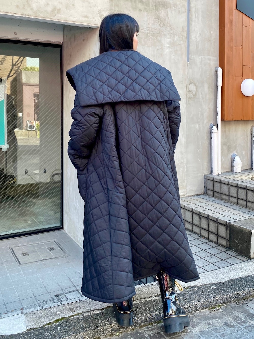 ブラック系のその他アウター、ホワイト系のスウェット、ブラック系のシューズを着用したレディースの秋コーディネートの3枚目の写真