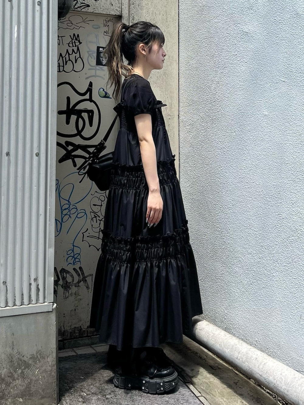 ブラック系のショルダーバッグ、ブラック系のワンピース、ブラック系のTシャツ/カットソーを着用したレディースの夏コーディネートの4枚目の写真