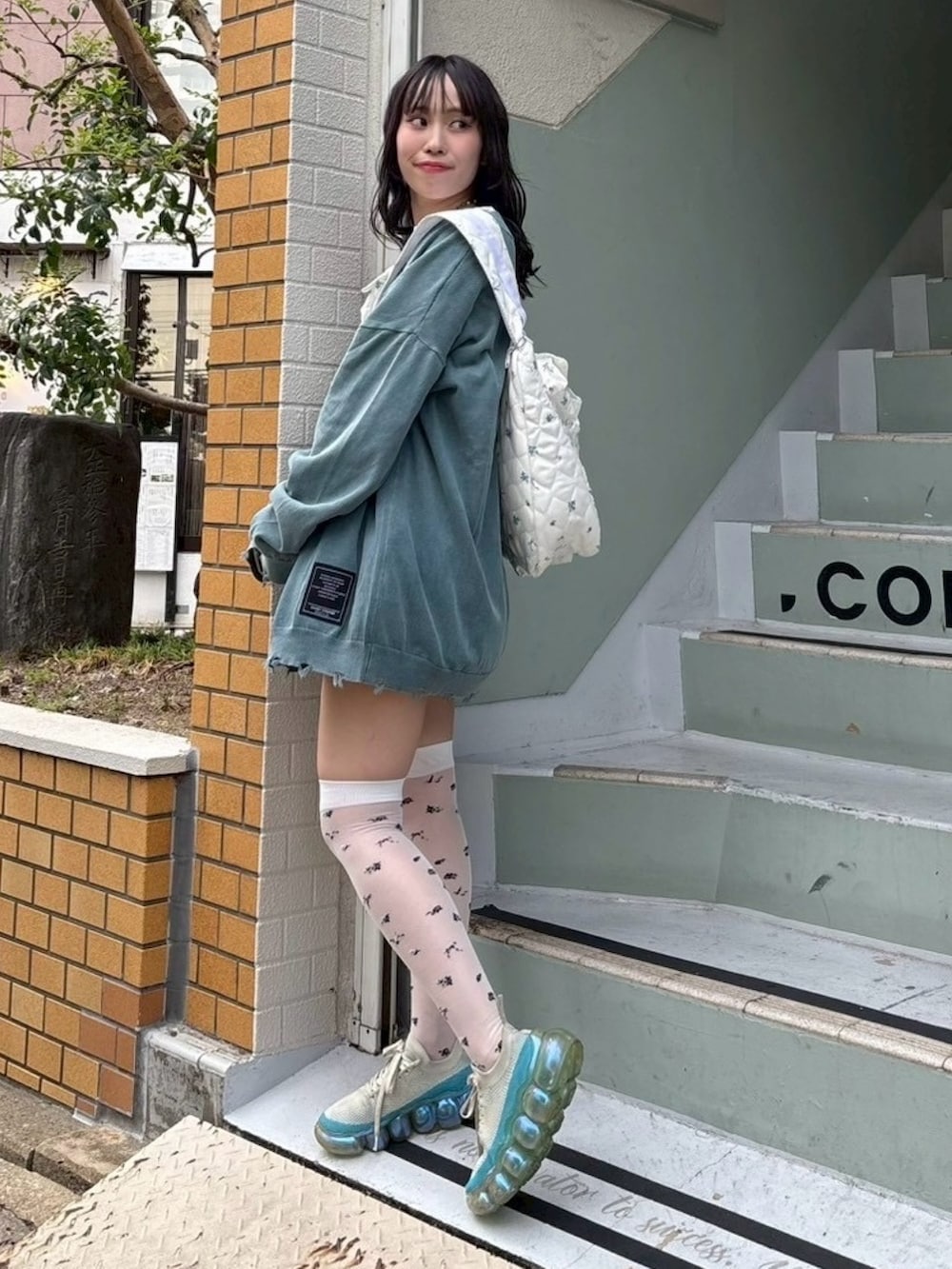 ホワイト系のTシャツ/カットソー、ブルー系のカーディガン/ボレロ、ホワイト系のスカートを着用したレディースの秋コーディネートの4枚目の写真