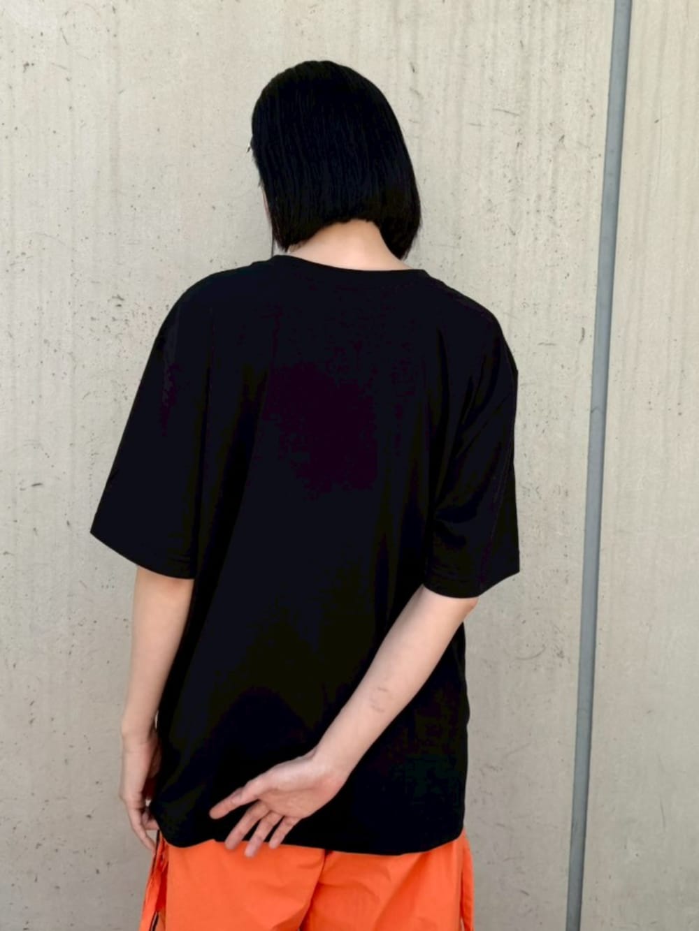 ブラック系のTシャツ/カットソー、オレンジ系のその他パンツを着用したレディースの春コーディネートの4枚目の写真