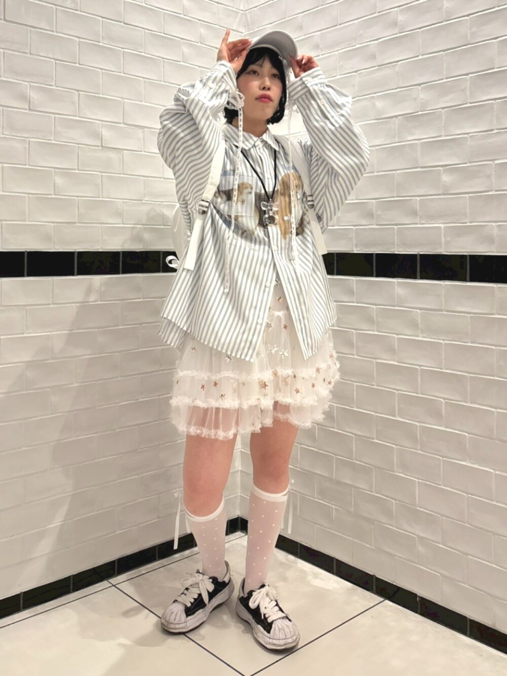 ブルー系のシャツ/ブラウス、ホワイト系のバックパック/リュック、ホワイト系のスカートを着用したレディースの冬コーディネートの2枚目の写真