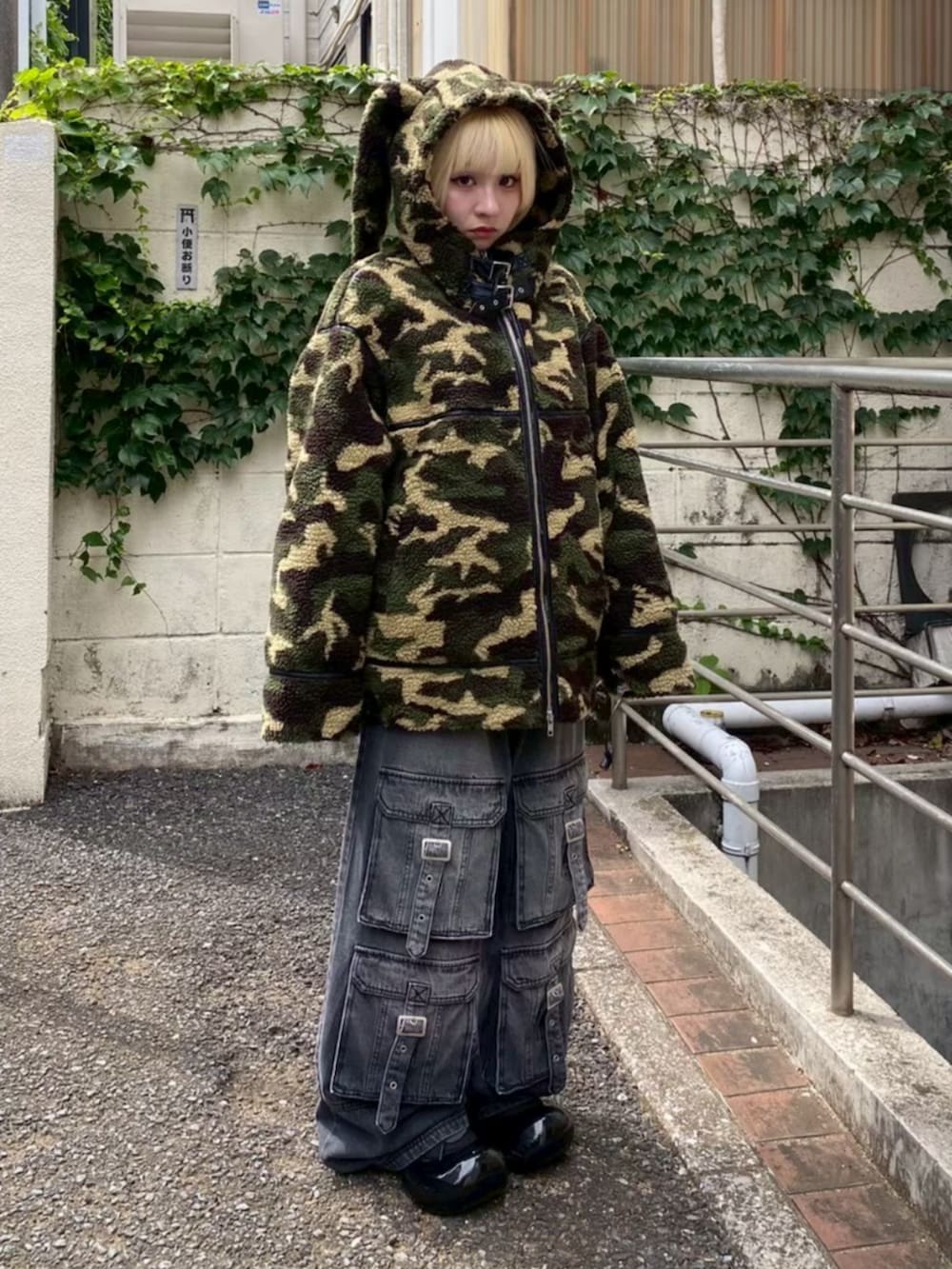 ブラック系のデニムパンツ、グリーン系のダウンジャケット/コート、レッド系のニット/セーターを着用したレディースの冬コーディネートの2枚目の写真