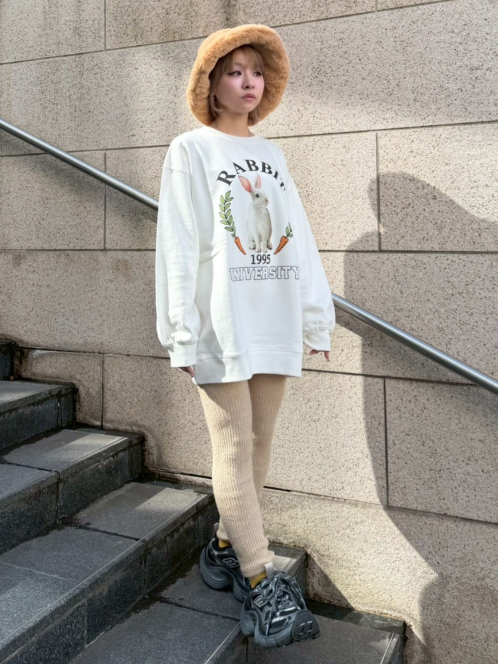 ホワイト系のスウェット、ブラウン系のハットを着用したレディースの冬コーディネートの2枚目の写真