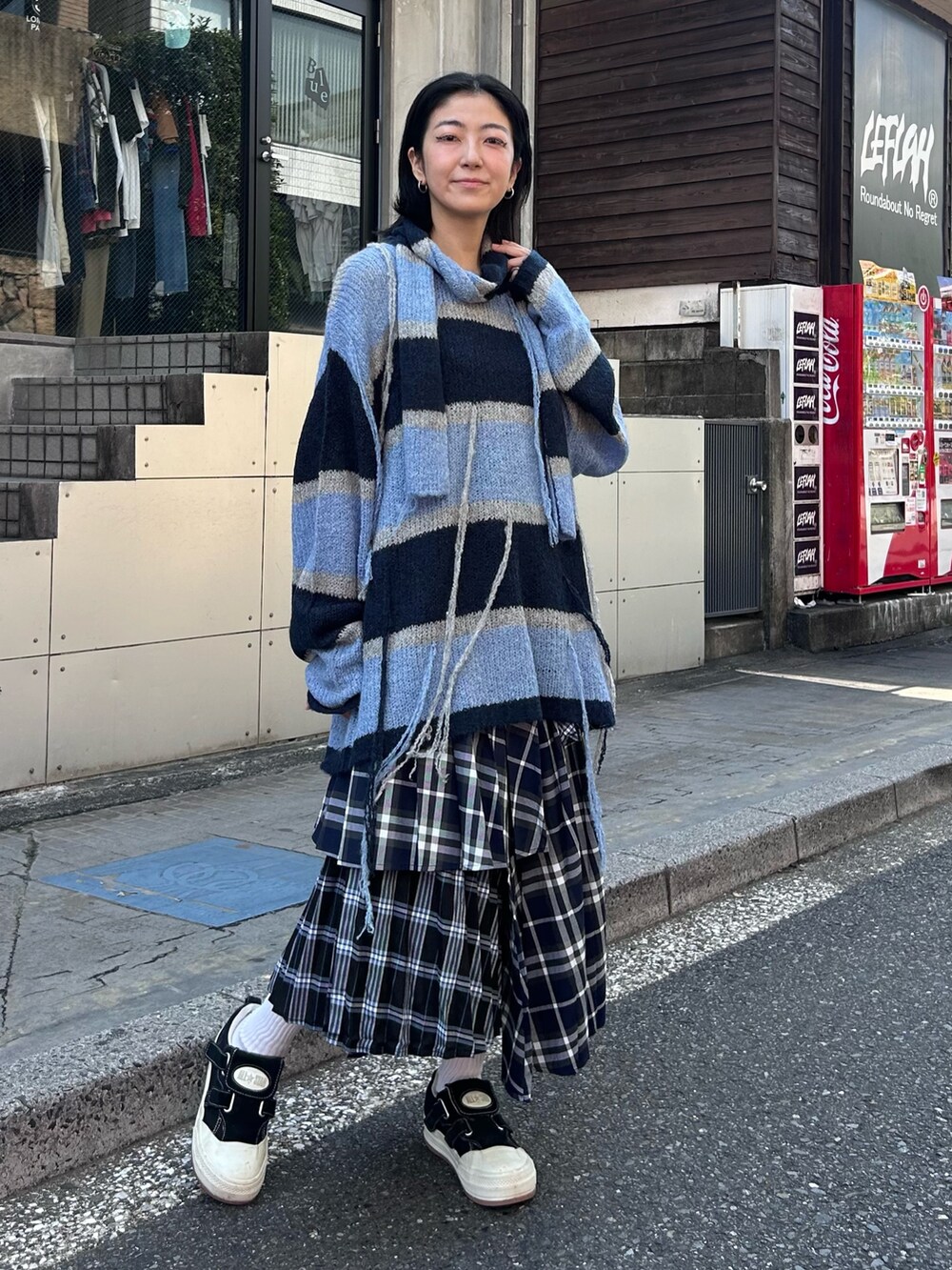 ブルー系のスカート、グレー系のニット/セーターを着用したレディースの秋コーディネートの2枚目の写真