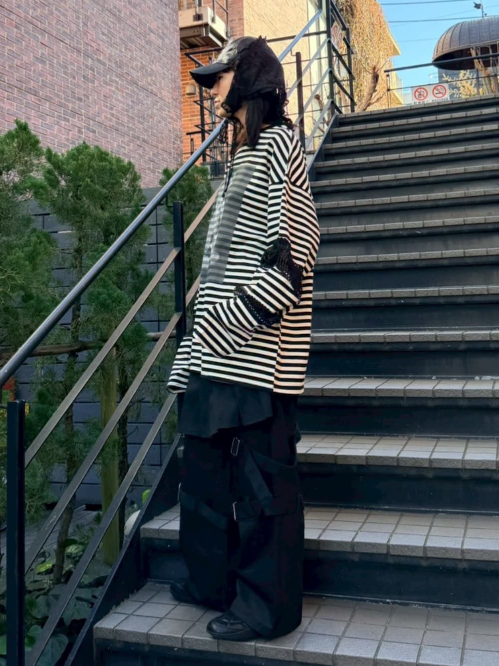 ブラック系のその他パンツ、ブラック系のTシャツ/カットソー、ブラック系のキャップを着用したレディースの冬コーディネートの2枚目の写真