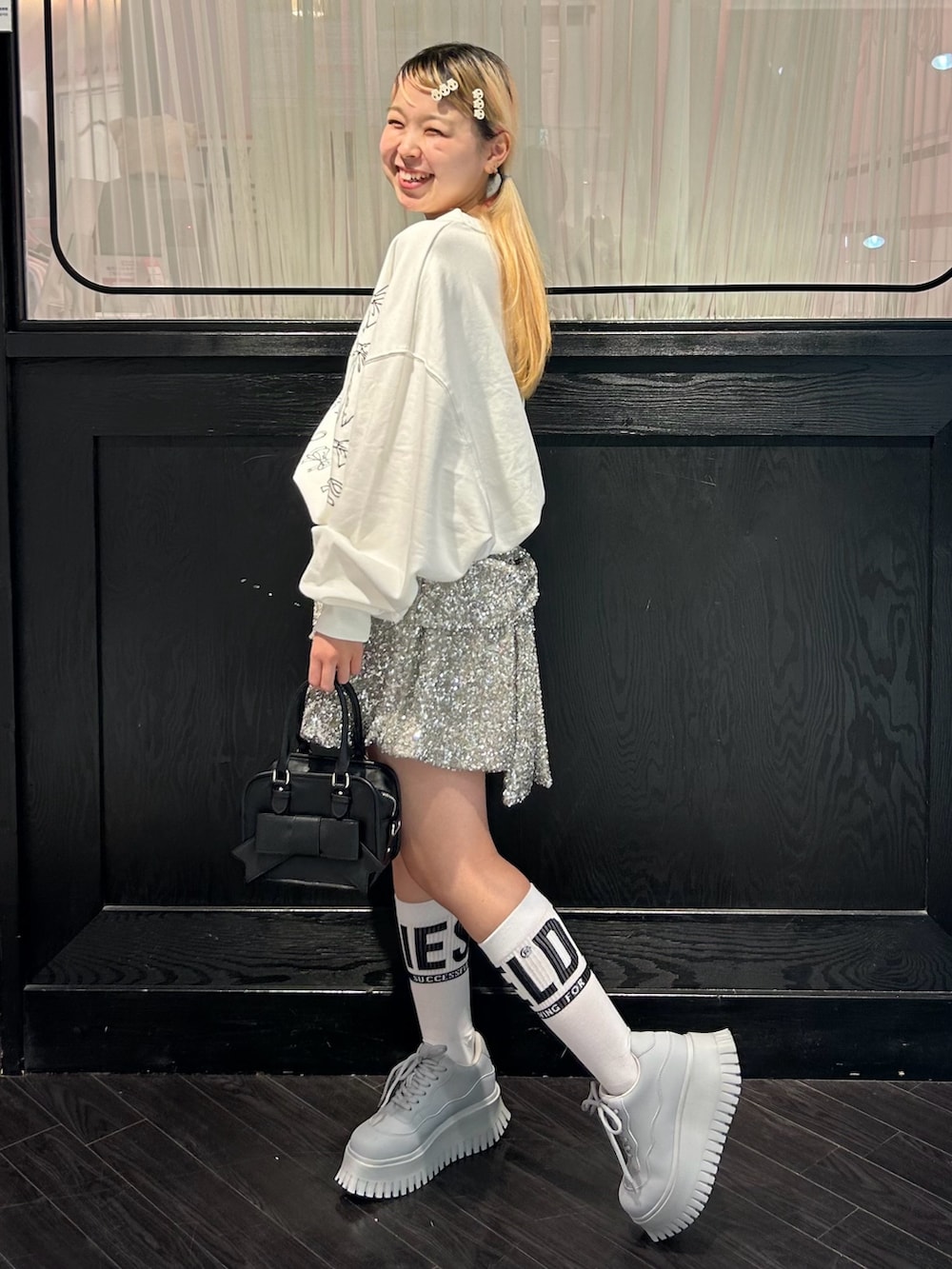 ホワイト系のスウェット、シルバー系のその他パンツ、ブラック系のショルダーバッグを着用したレディースの秋コーディネートの4枚目の写真